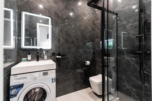 a bathroom with a washing machine and a shower at Квартира в стиле лофт in Almaty