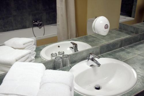 a bathroom with a sink and a mirror with towels at Hotel Kriopigi in Kriopigi