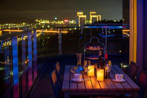a table on a balcony with a view of the city at Huafa Executive Apartment Hotel Zhuhai in Zhuhai