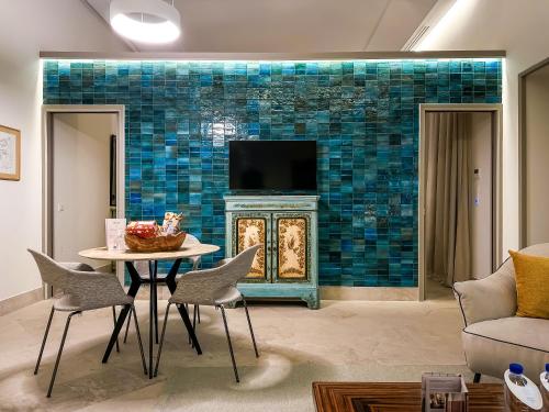 a living room with a table and a fireplace with a tv at Dar Ben Turkia in Tunis