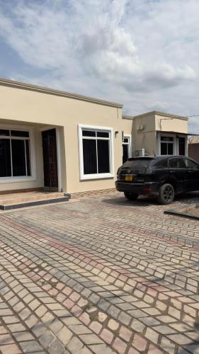 a black car parked in front of a house at Abode of peace Airport stay in Dar es Salaam