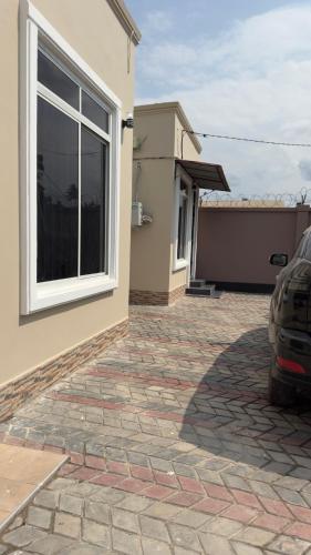 a house with a window and a car parked next to it at Abode of peace Airport stay in Dar es Salaam