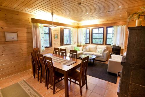 a dining room with a table and a living room at Tundrea Holiday Resort in Kilpisjärvi
