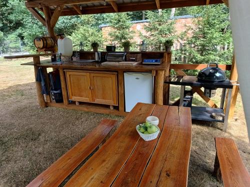 an outdoor kitchen with a table and a bowl of fruit at Wood Camping in Brochów