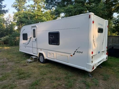 a white trailer parked in a field at Wood Camping in Brochów