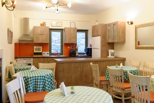 a dining room with two tables and a kitchen at Alexandra Hotel in Kalentzi