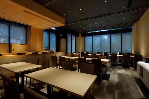 a dining room with tables and chairs and windows at Hotel Yaenomidori Tokyo in Tokyo