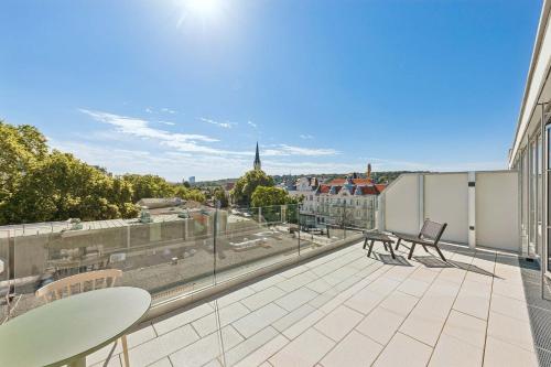 a balcony with chairs and a view of a city at Limehome Vienna Hietzinger Hauptstraße in Vienna
