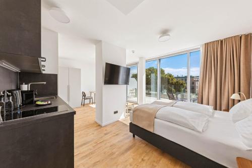 a bedroom with a king sized bed and a kitchen at Limehome Vienna Hietzinger Hauptstraße in Vienna
