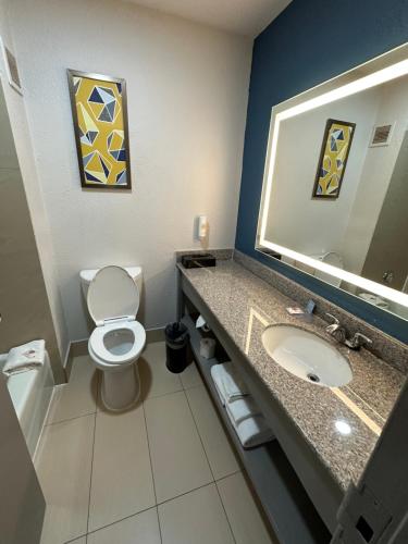 a bathroom with a toilet and a sink and a mirror at Comfort Inn Dallas Park Central in Dallas