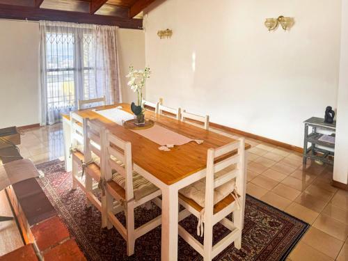 a dining room with a wooden table and chairs at Spacious 4Br Home In Bo Kaap With Mountain And Ocean View 5 min From Cape Town CBD in Cape Town