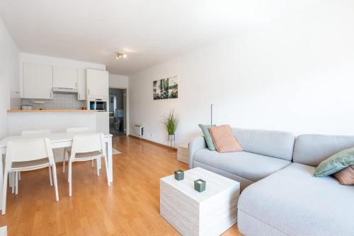 a living room with a couch and a table at Cosy condo in the city centre in Ostend