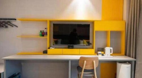 a yellow counter with a television in a room at 7 Days Inn Guangrao Bus Station in Dongying