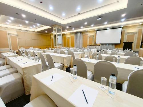 a conference room with tables and chairs and a screen at The Quarter Saphankhwai by UHG in Bangkok
