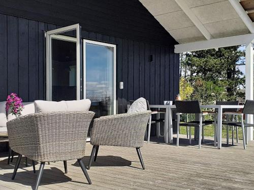 a patio with chairs and a table and a table and chairs at 5 person holiday home in Rømø in Kongsmark