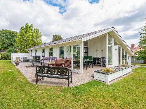 a house with a patio with a bench in the yard at 4 star holiday home in Juelsminde in Sønderby