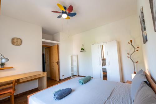 a bedroom with a bed with a ceiling fan and a desk at Parcheggio Privato - 5 minuti dal Lago di Varese in Varese