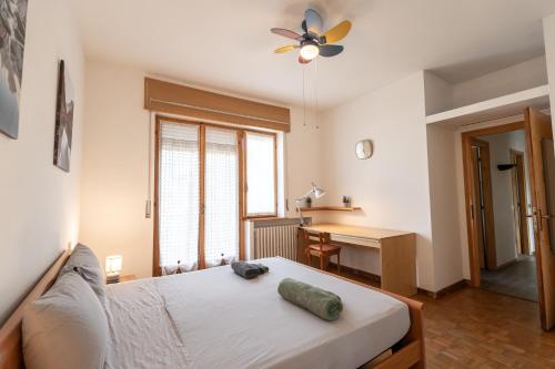 a bedroom with a bed with a ceiling fan and a desk at Parcheggio Privato - 5 minuti dal Lago di Varese in Varese