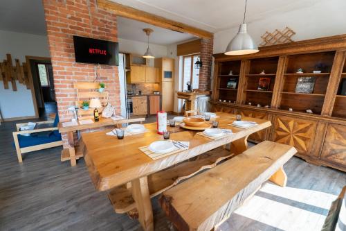 a dining room with a large wooden table with benches at Parcheggio Privato - 5 minuti dal Lago di Varese in Varese