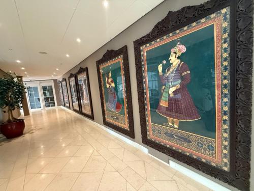 a hallway with a row of paintings on the wall at Grand Hôtel du Golf & Palace in Crans-Montana