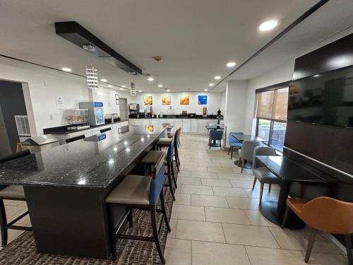 a restaurant with a large counter and tables and chairs at Comfort Inn Dallas Park Central in Dallas