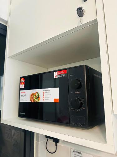 a microwave oven in a shelf in a kitchen at Langit dan Lantai #168ParkSelayangMall #HospitalSelayang #UitmSelayang in Kampong Jawa Tengah