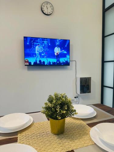 a living room with a table and a tv on the wall at Langit dan Lantai #168ParkSelayangMall #HospitalSelayang #UitmSelayang in Kampong Jawa Tengah