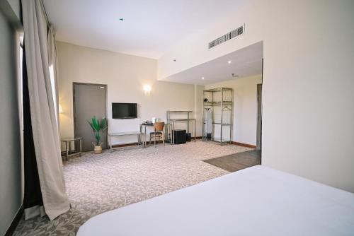 a large room with a bed and a tv at Kingston Hotel 10 - Bukit Jalil in Serdang