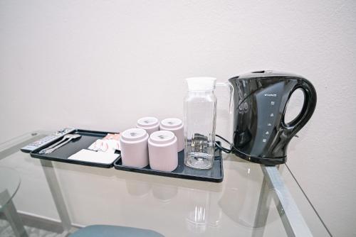 a glass table with a blender and cups on it at Kingston Hotel 10 - Bukit Jalil in Serdang