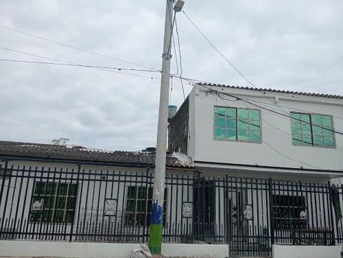 un edificio bianco con finestre verdi e un palo di CARTAGENA MAR a pocas cuadras a Estación El Salto