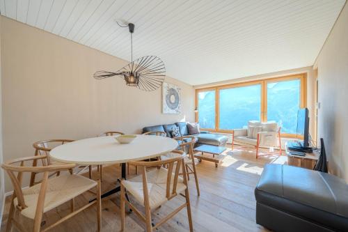 a living room with a table and chairs at Viktoria B33 by Arosa Vacations, Exklusive App mit Bergblick im Zentrum in Arosa
