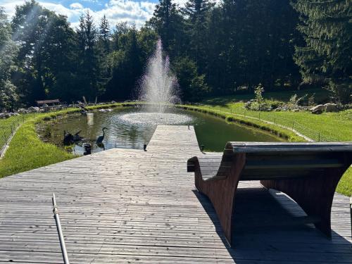 a park with a fountain and a pond with ducks at Landhaus Gschaiderhof in Puchberg am Schneeberg
