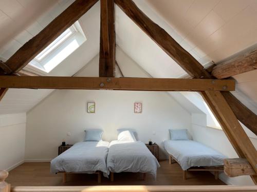 two beds in a attic room with wooden beams at La ruche - maison de 10 à 15 personnes - La Ferme du Try in Frasnes-lez-Gosselies