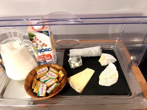 a plastic container with cheese and other food in a refrigerator at Hôtel Le Plantagenet in Chinon