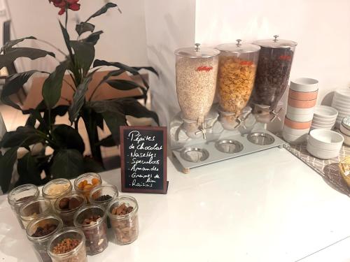 a table with several glass vases filled with food at Hôtel Le Plantagenet in Chinon
