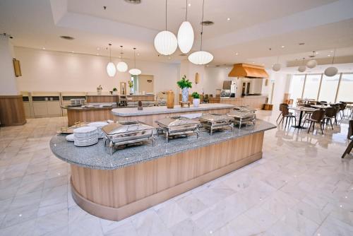 a large kitchen with a counter with dishes on it at Kingston Hotel 10 - Bukit Jalil in Serdang