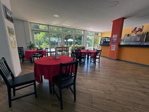 a restaurant with tables and chairs with red table cloth at Atikiana casa per ferie in Bee