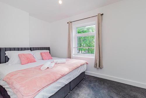 a bedroom with a bed with a window at Stunning 3-Bedroom Home in Bletchley - Close to City Centre and Train Station - Free Private Parking - Fast Wi-Fi and Smart TV in Bletchley