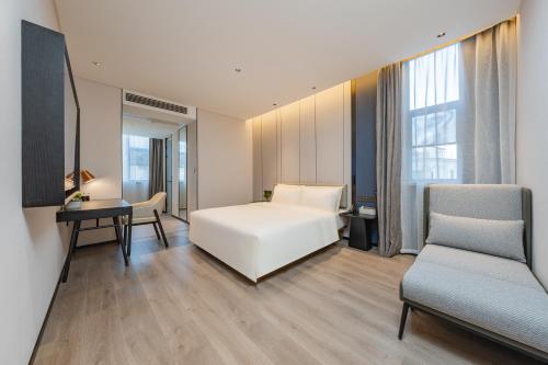 a bedroom with a bed and a desk and a chair at Atour Hotel Guangzhou Pazhou Exhibition Center Information Port-Free shuttle bus to Canton Fair in Guangzhou