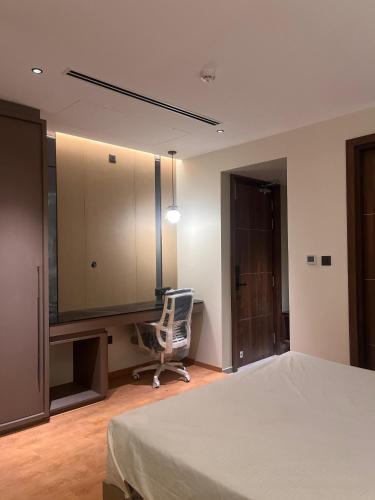 a bedroom with a bed and a desk and a chair at FHotels in Bengaluru