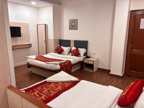 a hotel room with two beds and a tv at Hotel Garden View - Near Karol Bagh Metro Station and Gaffar Market in New Delhi