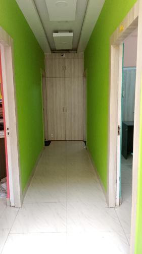 an empty room with green walls and white floors at Rhino Inn Guest House in Guwahati
