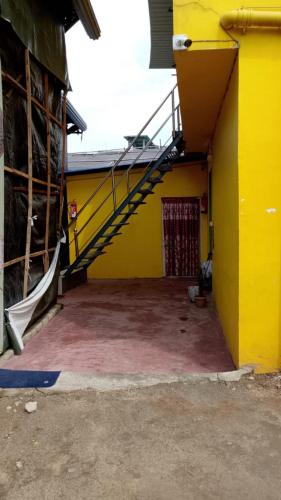 a yellow building with a staircase on the side of it at Rhino Inn Guest House in Guwahati