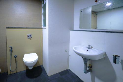 a bathroom with a sink and a toilet at Hotel Heraa Boarding Lodging in Mangalore
