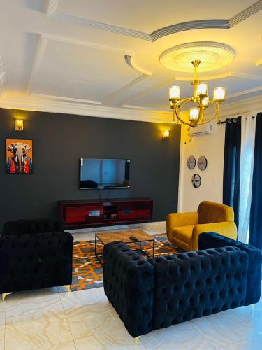 a living room with a couch and a flat screen tv at Résidence O-calme in Yaoundé