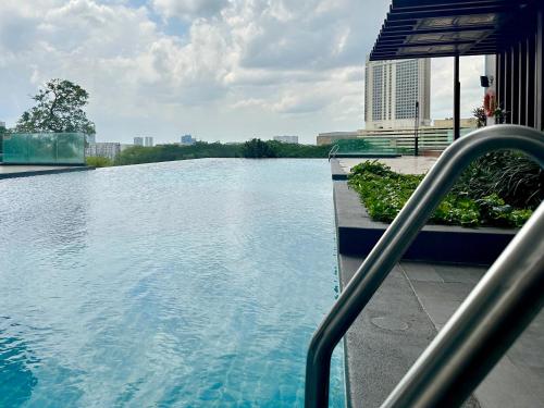 a swimming pool with blue water in a city at Mid Vally Southkey JB, 2BR, WIFI, 7 mins to CIQ , 5-7pax in Johor Bahru