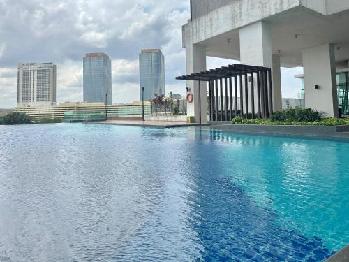 a swimming pool in front of a building with tall buildings at Mid Vally Southkey JB, 2BR, WIFI, 7 mins to CIQ , 5-7pax in Johor Bahru