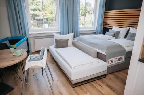 a bedroom with two beds and a couch and a table at Coffee Fellows Hotel & Longstay in Pfaffenhofen an der Ilm