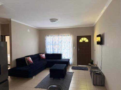 a living room with a couch and a table at Ocean View Cottage in Swakopmund