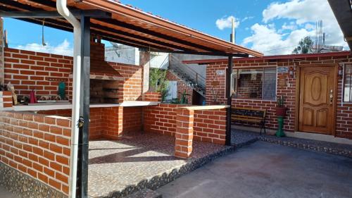 an outdoor patio with a brick wall and awning at Häuschen nahe Cotopaxi-House near Cotopaxi in Machachi